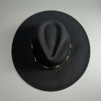 Black hat with gold band on a light gray background