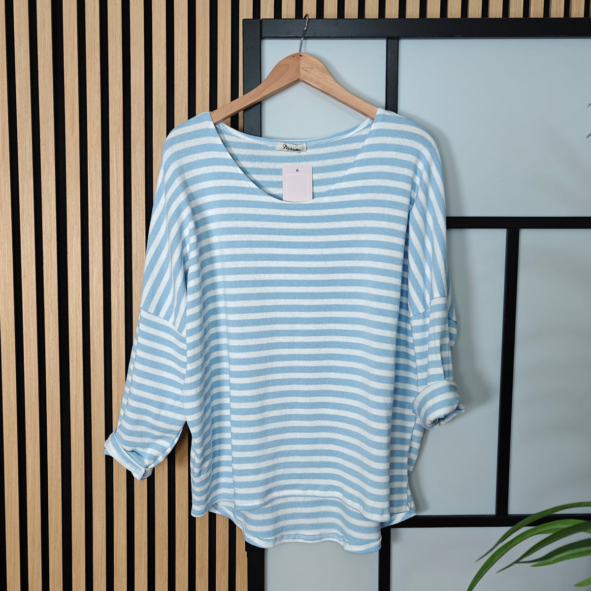 Sky Blue and white striped shirt on a hanger against a neutral background
