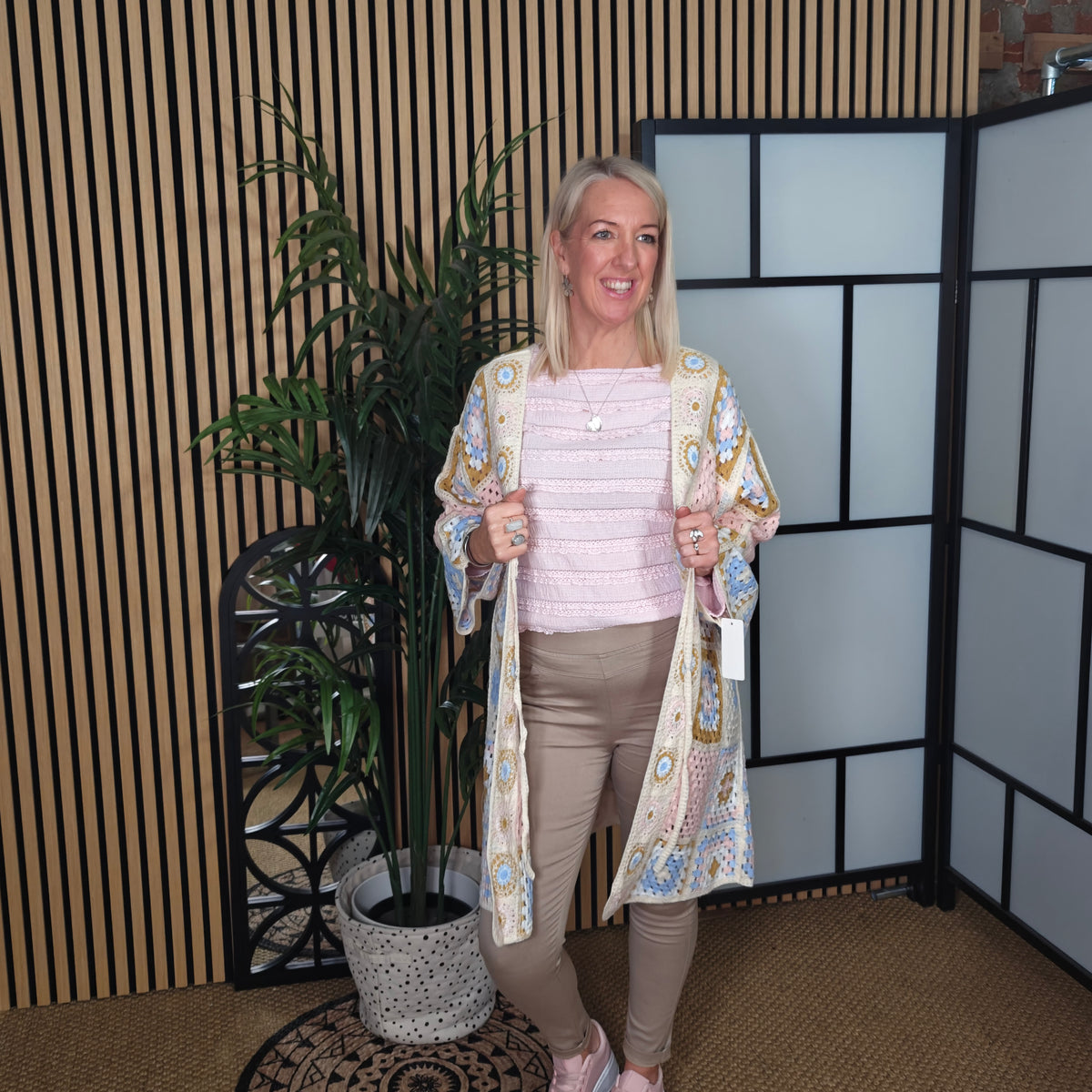 Woman standing in a room with decorative elements and plants