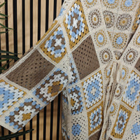 Crocheted jacket with a geometric pattern in brown, blue, and beige colors.