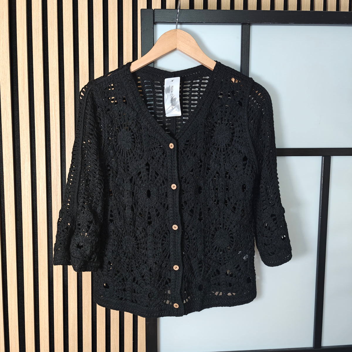 Darcy crochet buttoned jacket hanging on wall 