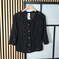 Darcy crochet buttoned jacket hanging on wall 