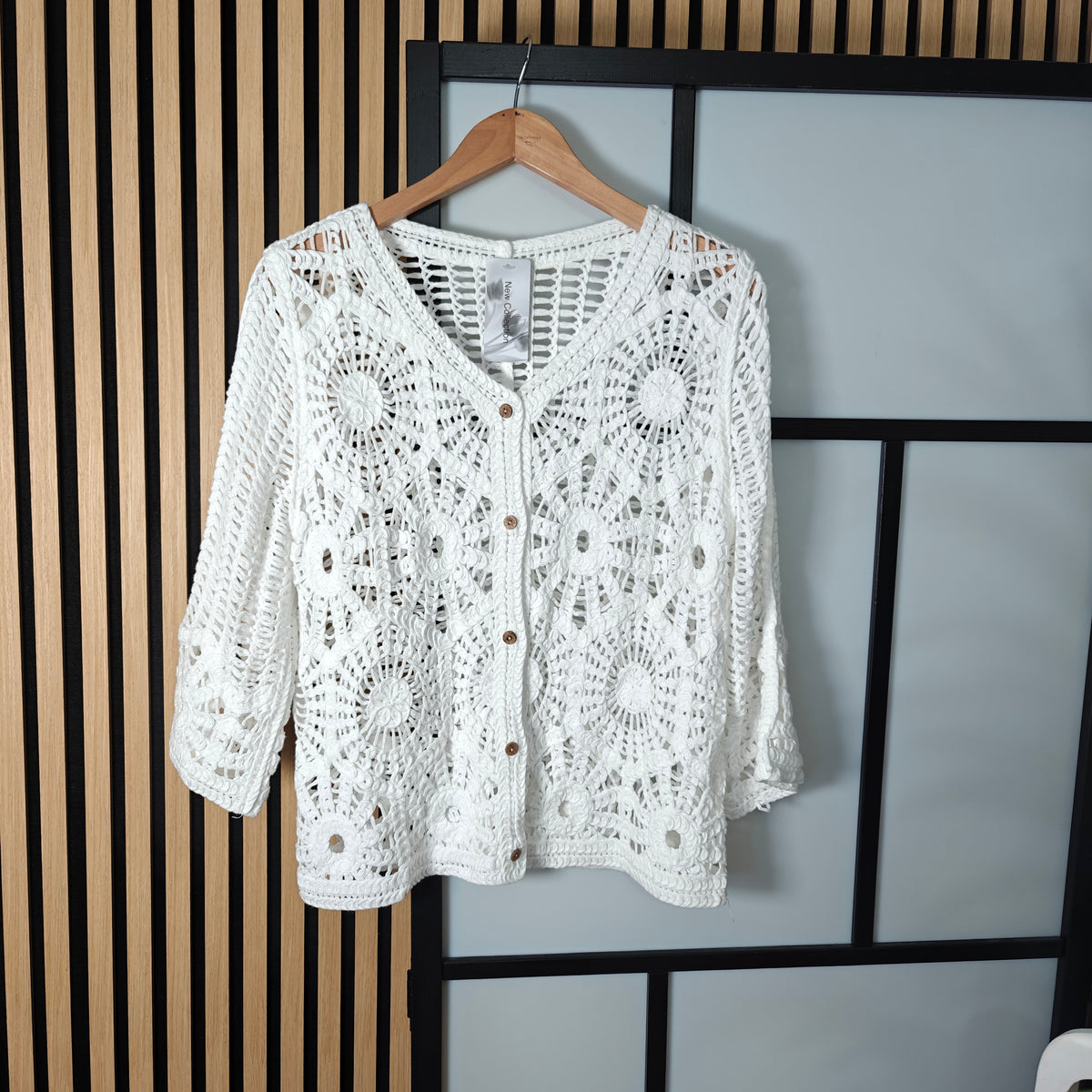 Darcy crochet buttoned jacket white hanging up on wall