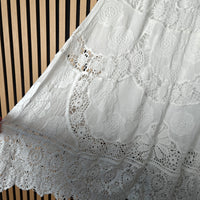 Close-up of white lace fabric with a striped background