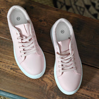 Pair of pink sneakers on a wooden surface