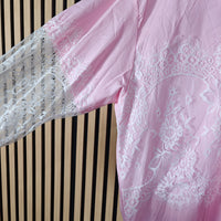 Close-up of a pink lace garment against a striped background