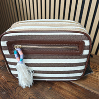 Striped bag with a tassel on a wooden surface