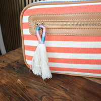 Striped handbag with a tassel on a wooden surface