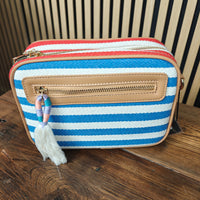 Striped purse with a tassel on a wooden surface