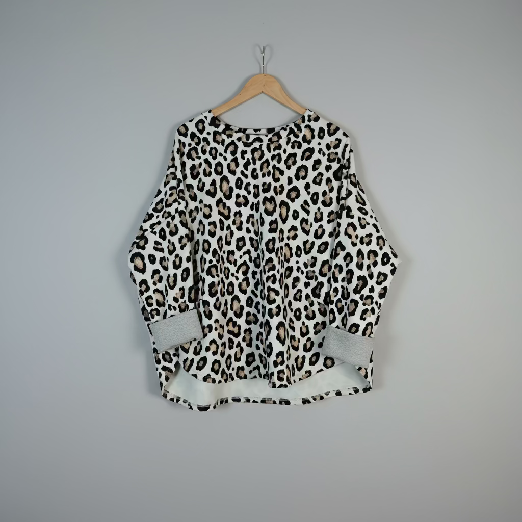 Leopard print top on a hanger against a plain background