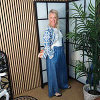 Woman in a stylish outfit standing in a room with decorative elements