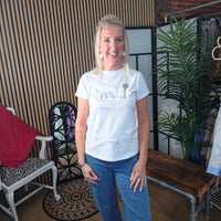 Woman wearing a white t-shirt with a logo in a casual indoor setting